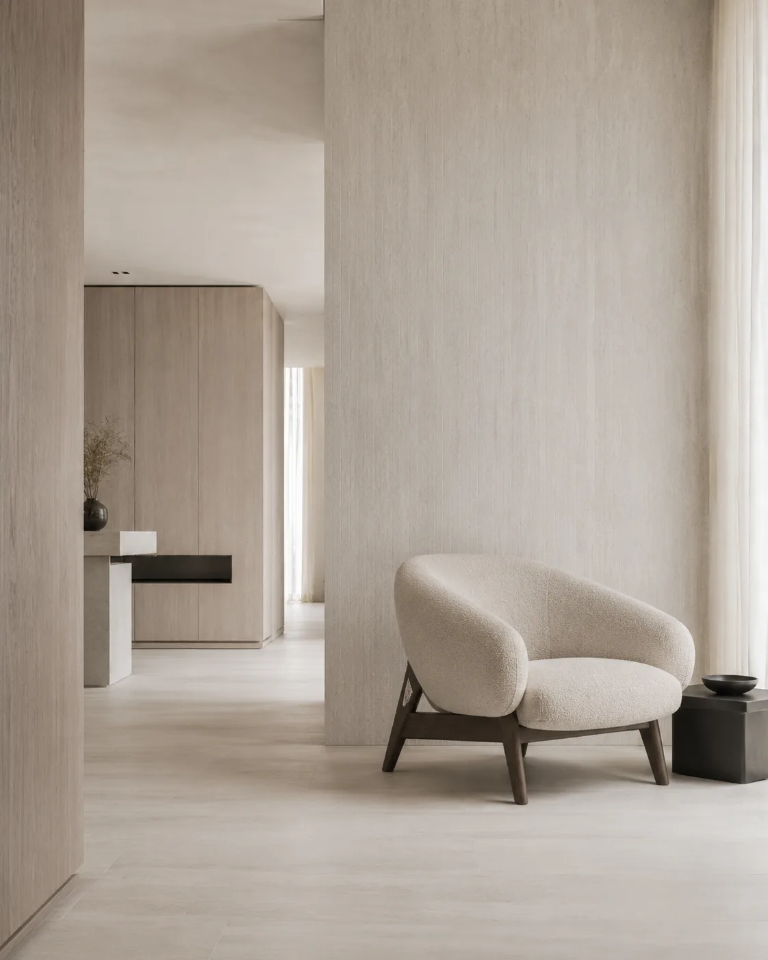 Interno con poltrona e parete materica